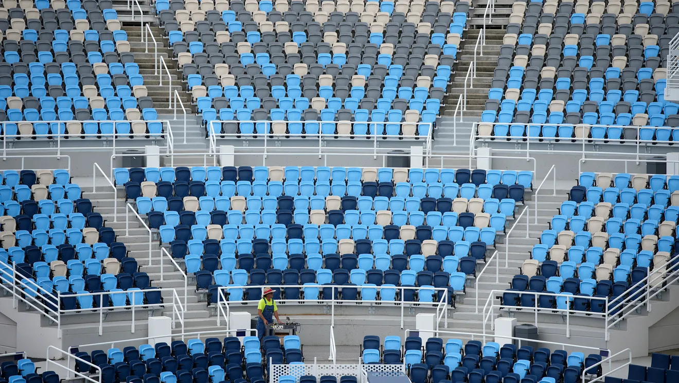a large grouping of empty blue and white tennis centre seats