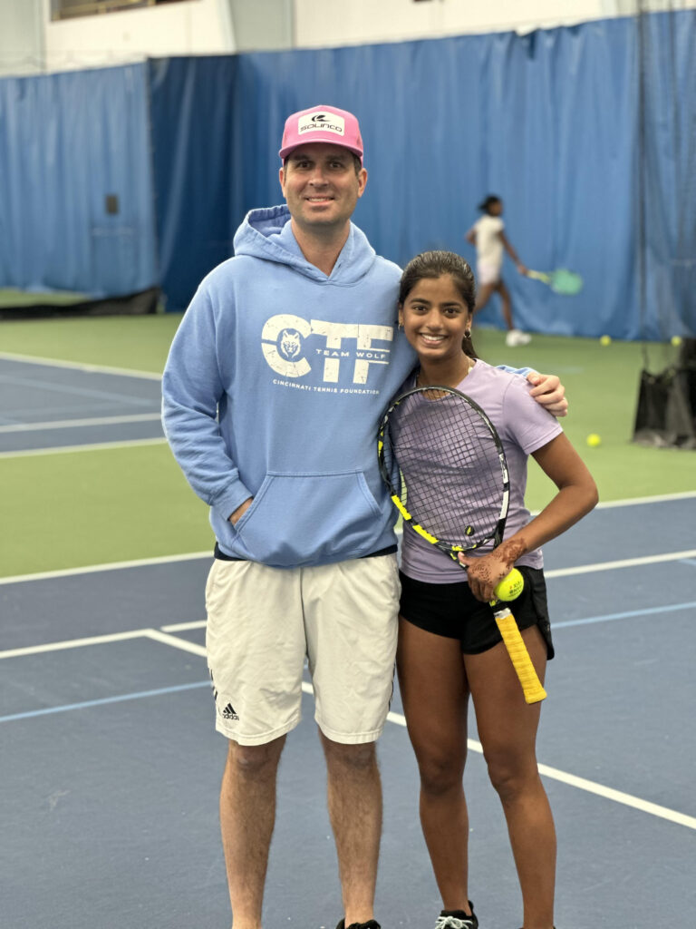 coach posing with young tennis student