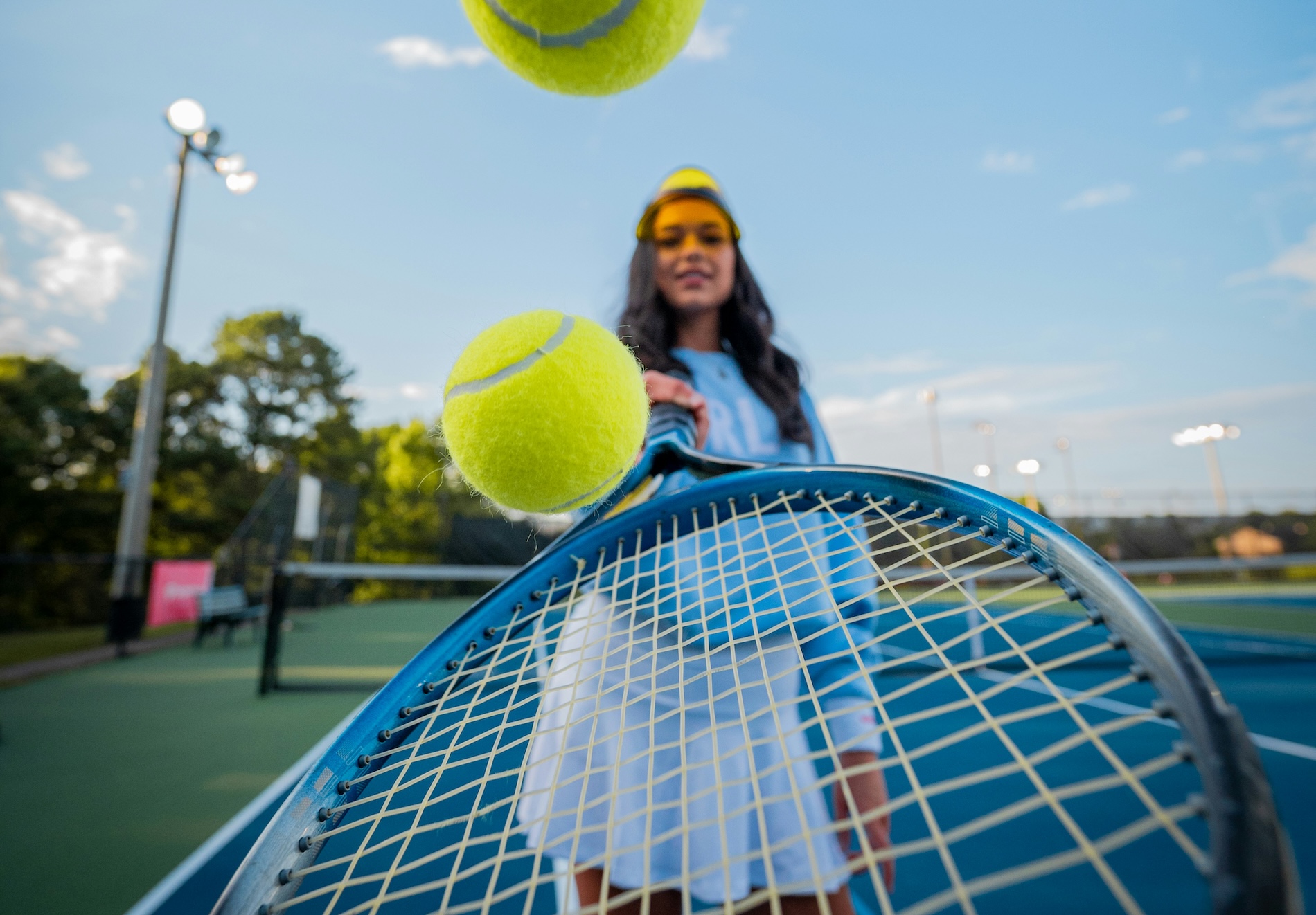 person bounce tennis balls on a racquet