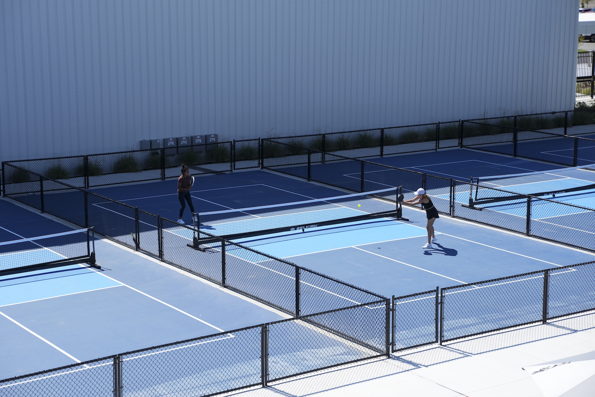 Two people playing on a pickleball court
