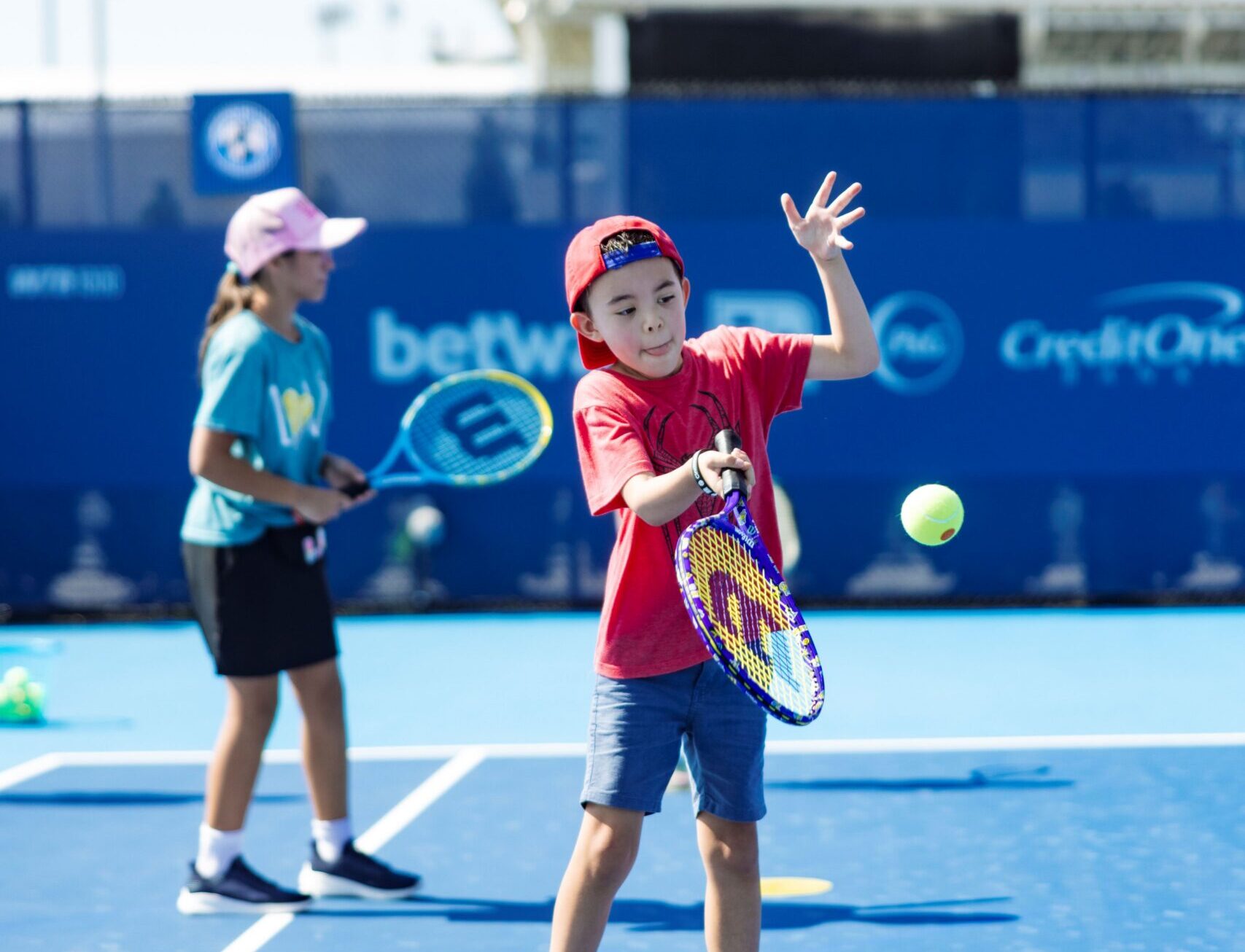 Child hits a tennis ball at the Cincinnati Open Sporting CLub