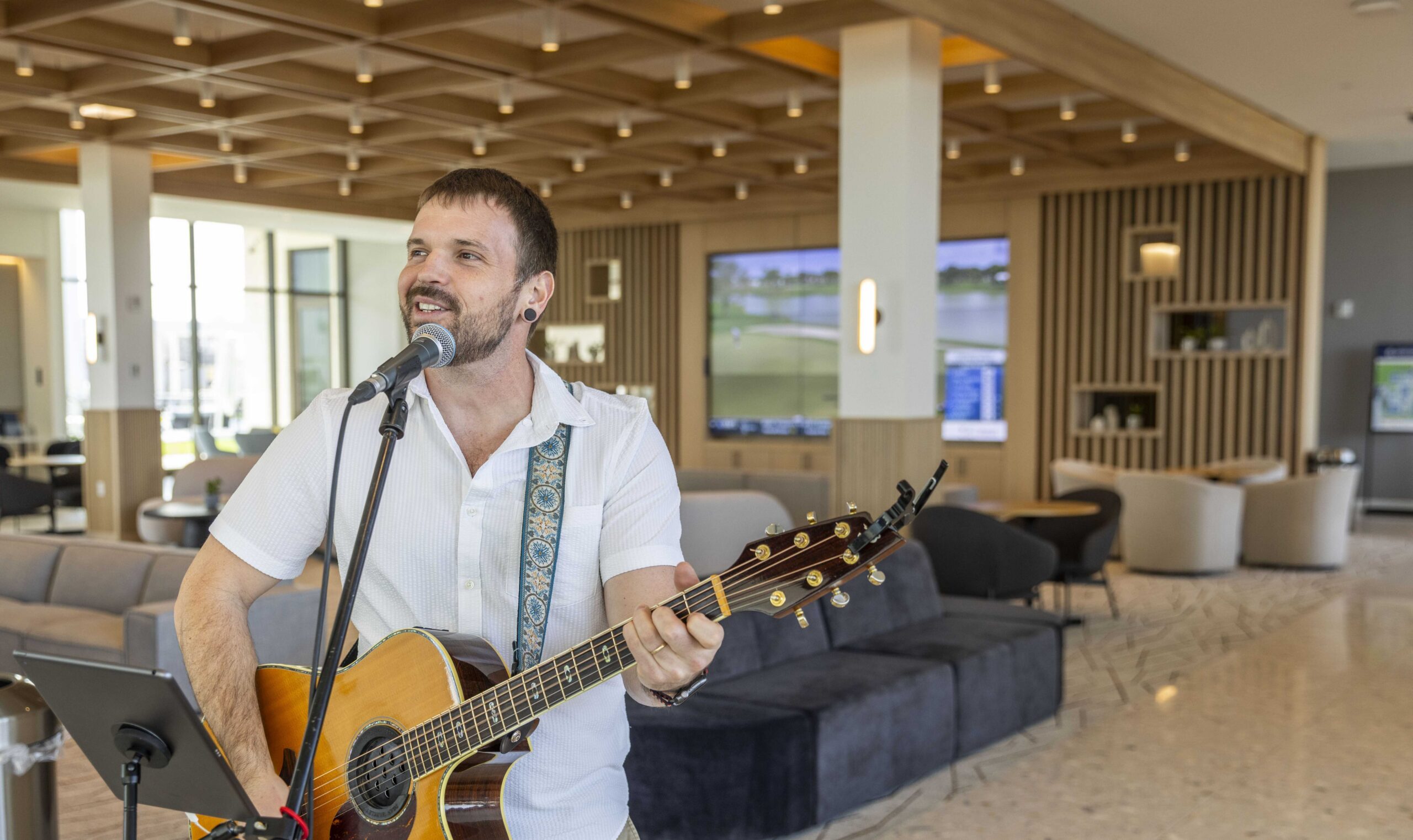 Man singing into microphone while playing guitar
