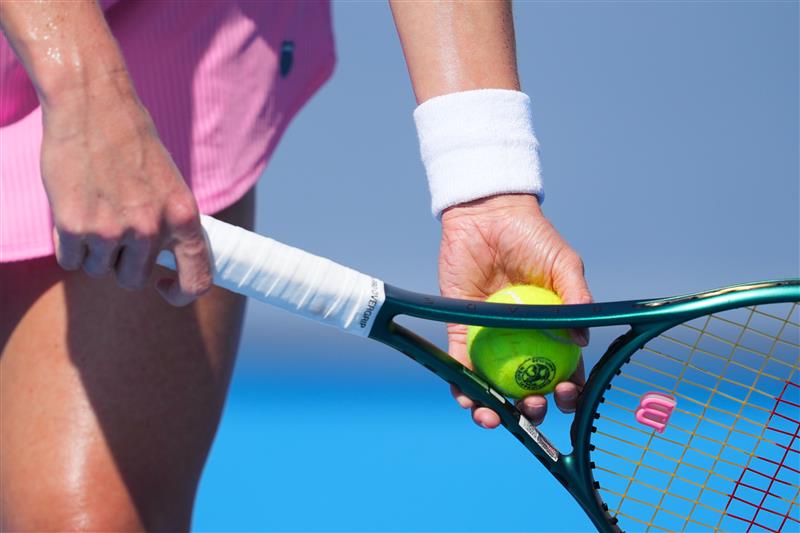 women holding tennis ball and racquet in her hand