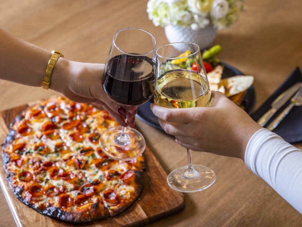 two people cheersing their glasses of wine
