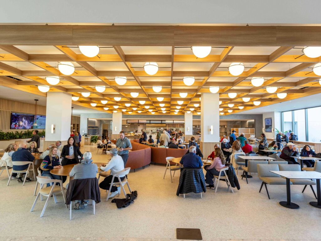 Multiple tables filled with people talking inside a restaurant